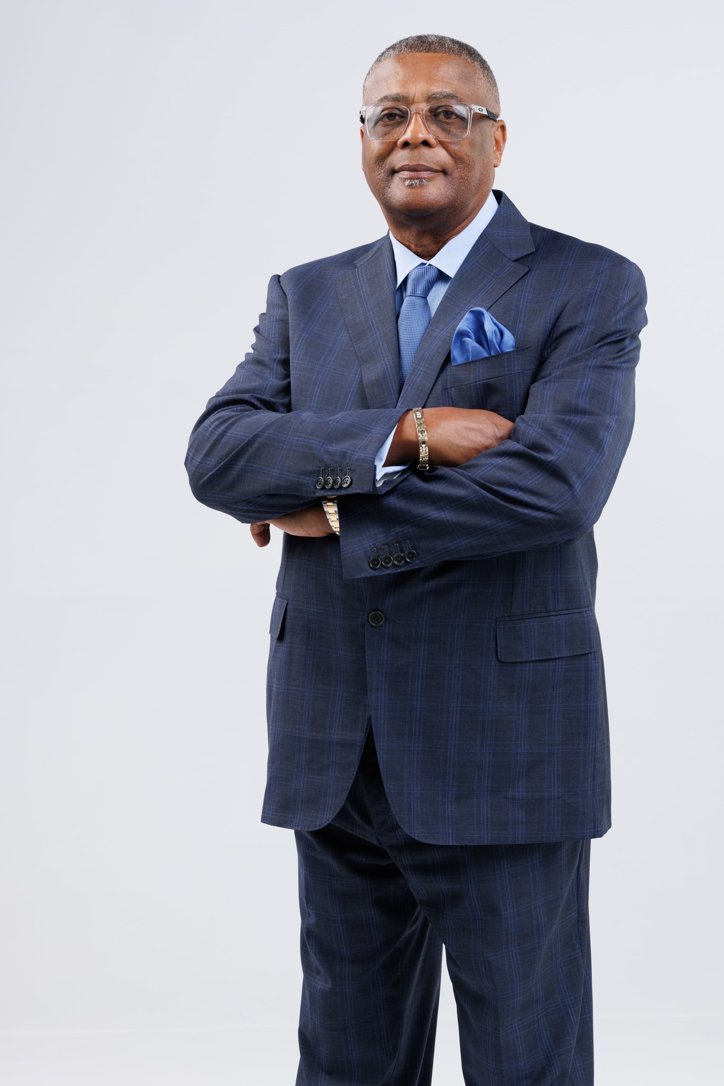 Portrait of Dennis Dabney in a navy suit with arms crossed
