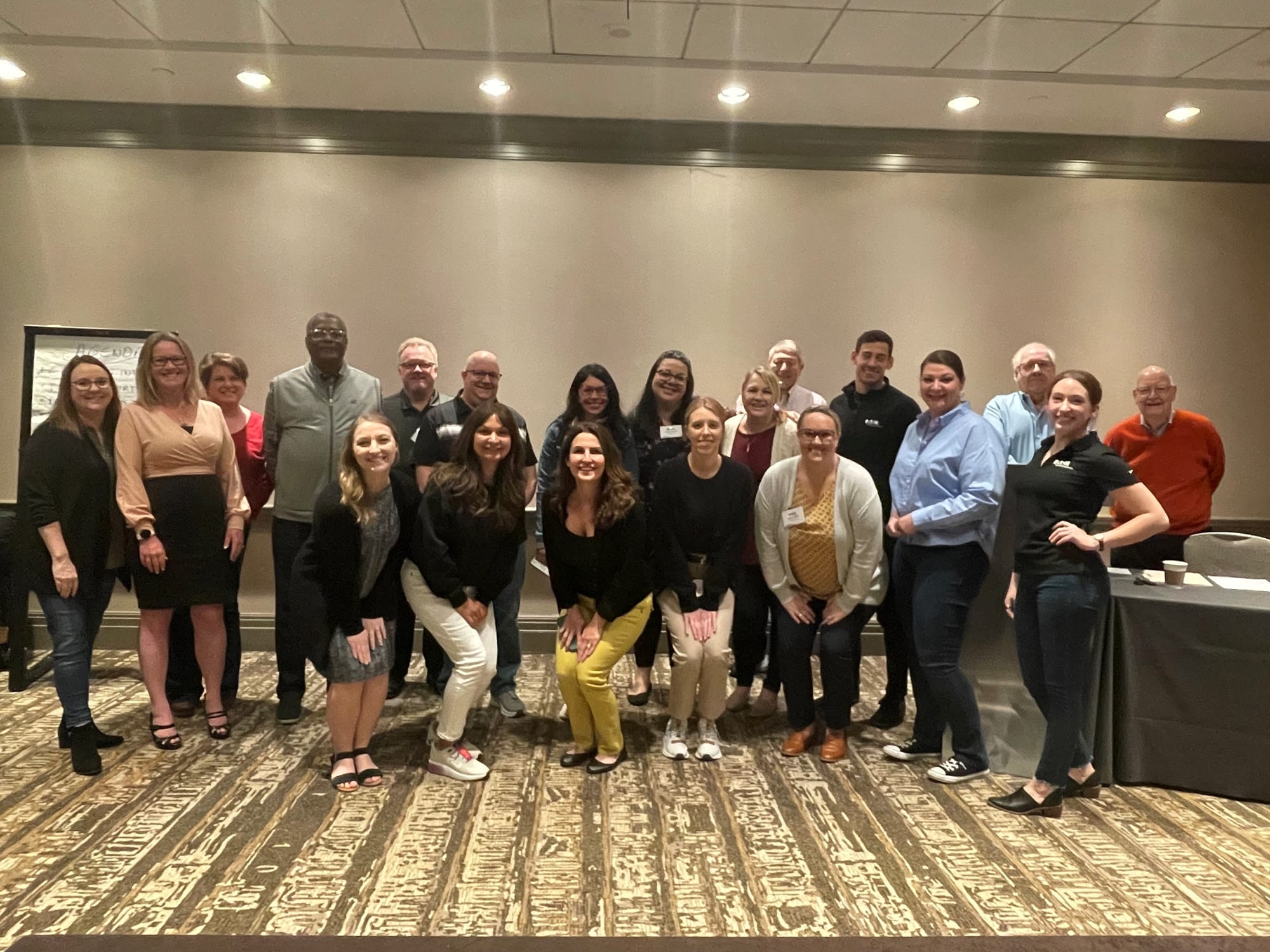 Dennis Dabney with a large group of colleagues in a hotel ballroom
