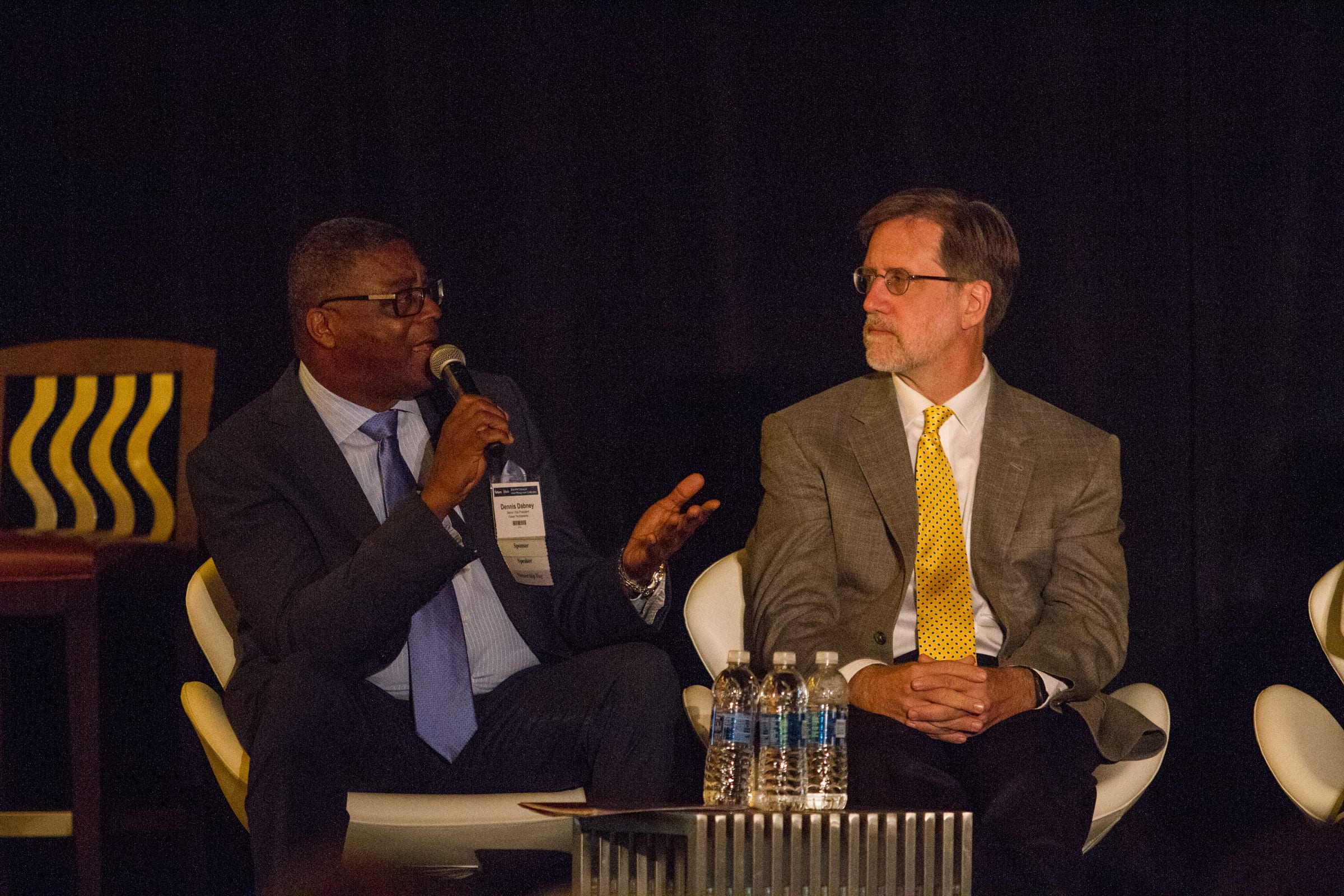 Dennis Dabney in discussion with a fellow panelist on stage